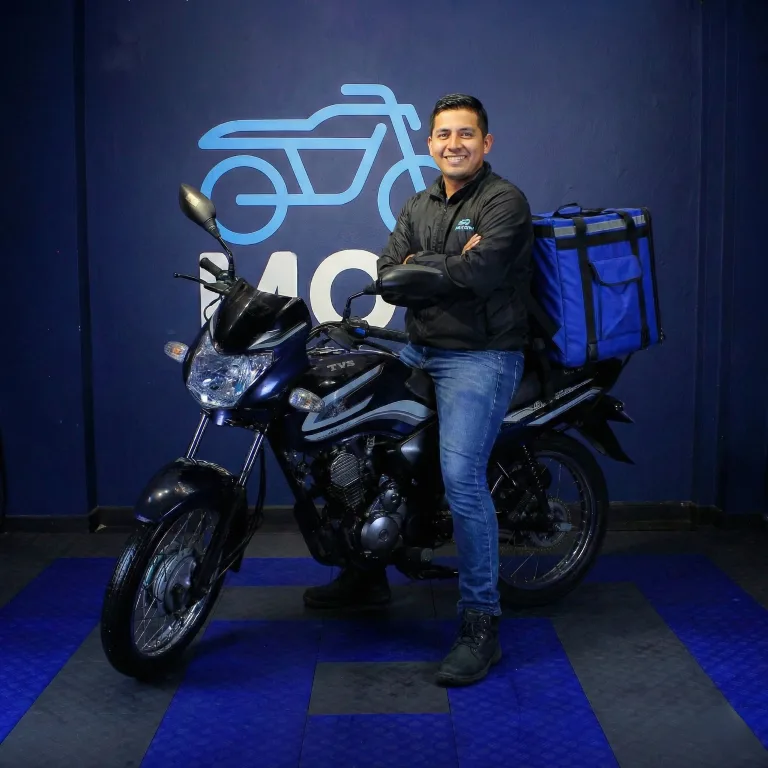Repartidor posando con su motocicleta de trabajo Motai